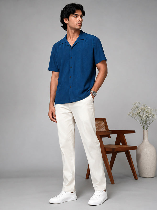 Men's royal blue textured shirt styled with white trousers