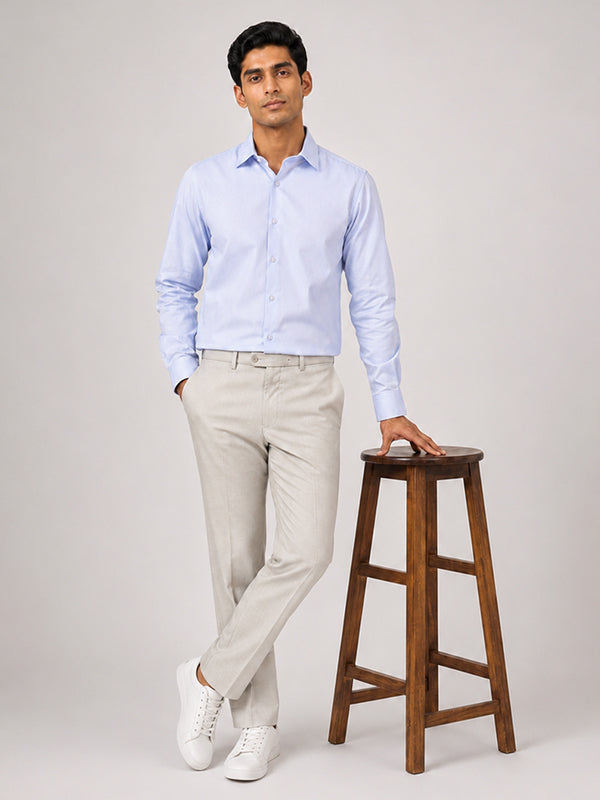 Men's sky blue cotton shirt styled with beige trousers, full-length view