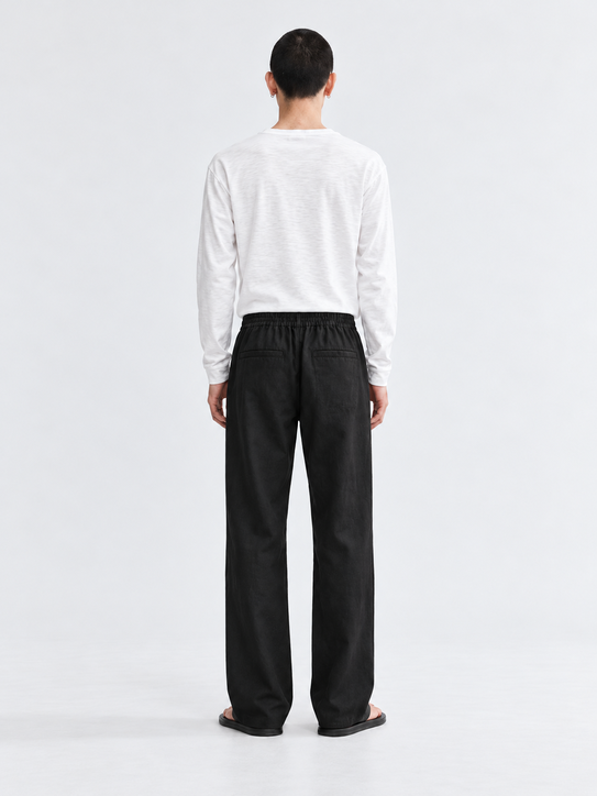 DILI men's black relaxed straight-fit drawstring trousers styled with a white Henley T-shirt.