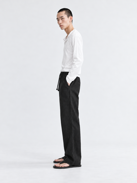 DILI men's black relaxed straight-fit drawstring trousers styled with a white Henley T-shirt.