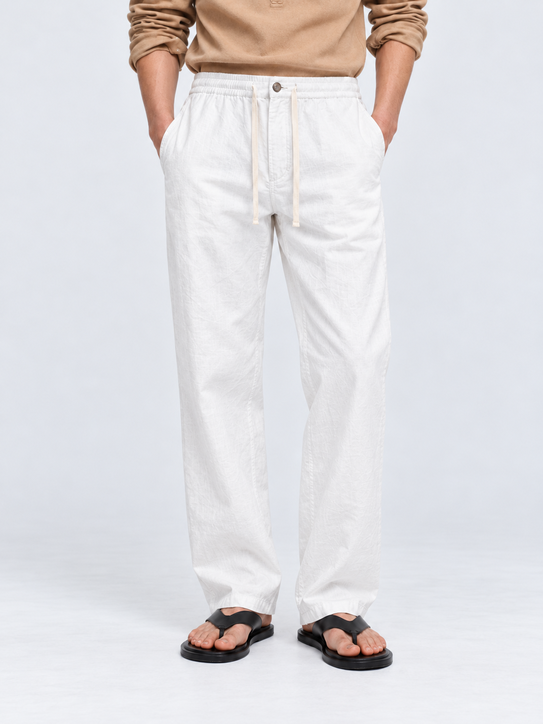 DILI men's white relaxed straight-fit trousers with adjustable drawstrings, styled with a beige Henley T-shirt.