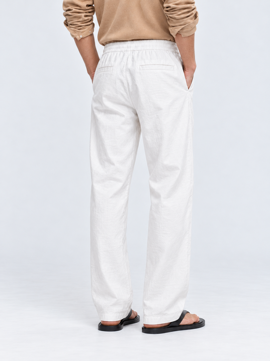 DILI men's white relaxed straight-fit trousers with adjustable drawstrings, styled with a beige Henley T-shirt.