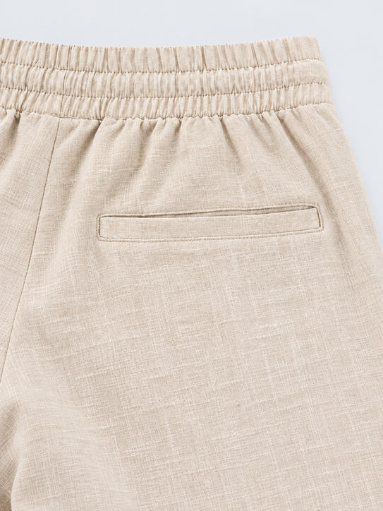 DILI men's beige relaxed straight-fit trousers, front view with drawstring waist.