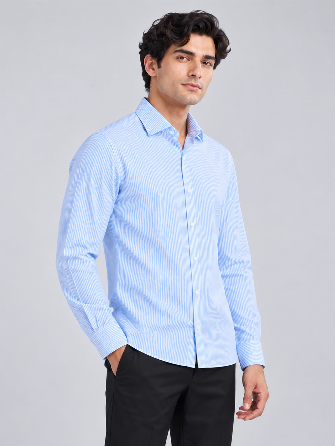 Model wearing light blue striped DILI shirt with black trousers
