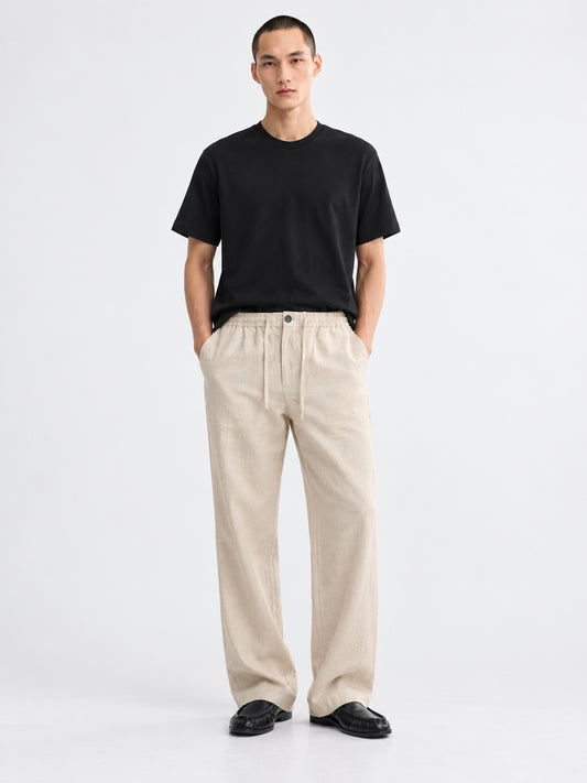 Model wearing DILI men's beige linen-cotton relaxed straight-fit trousers