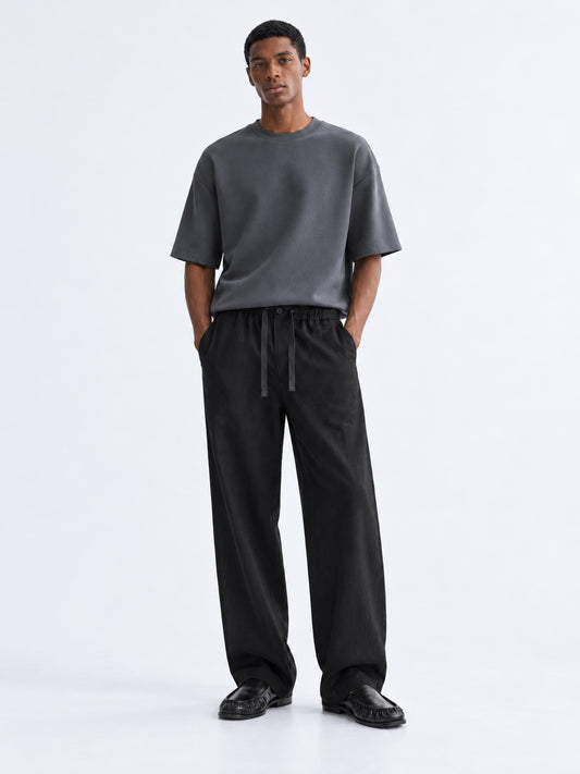 Model wearing DILI black linen-cotton relaxed straight-fit trousers