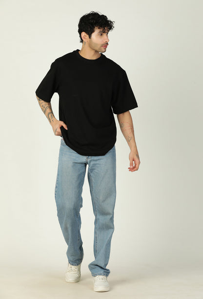Full-length view of men's solid black oversized cotton T-shirt