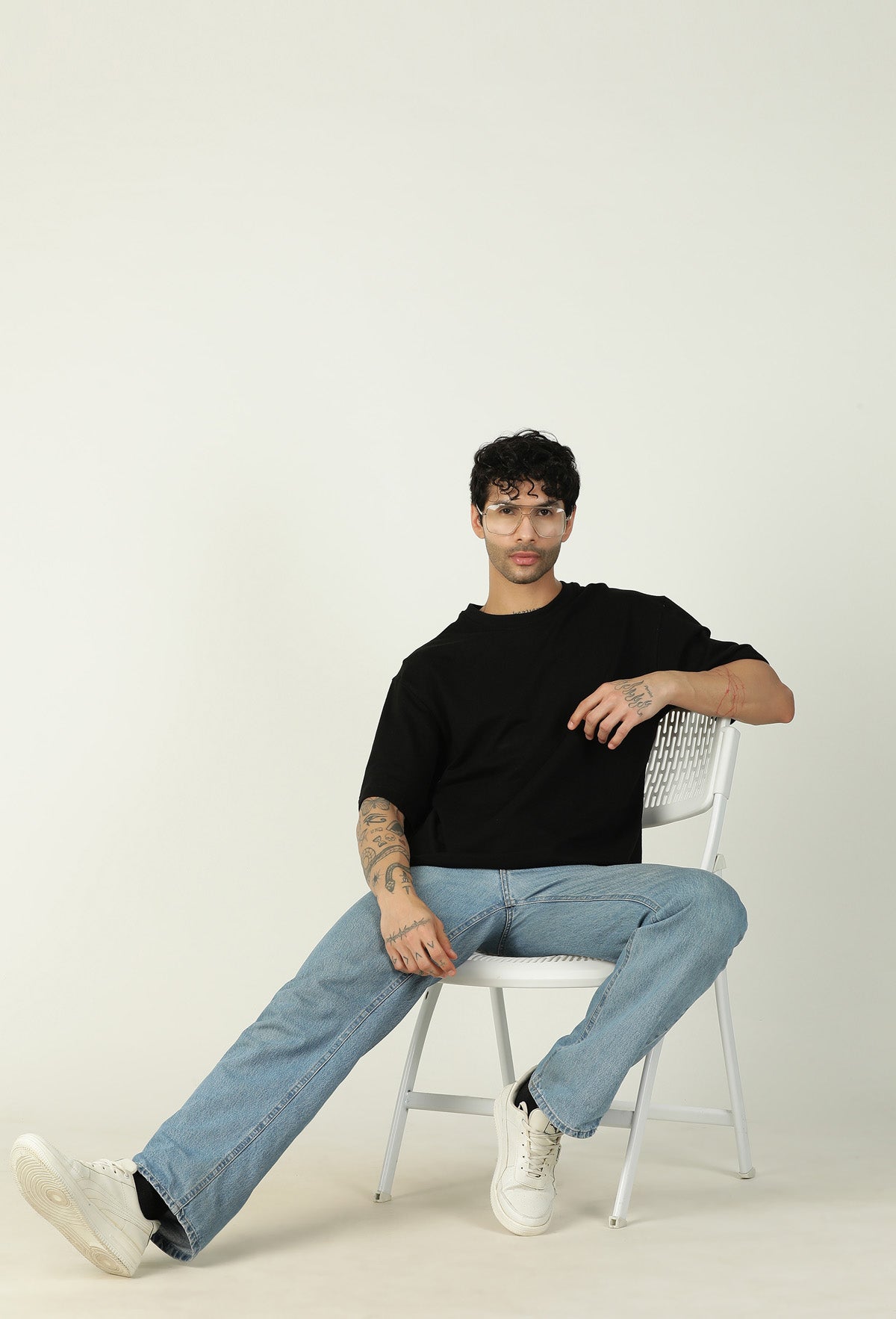 Men's black oversized cotton T-shirt styled with blue jeans