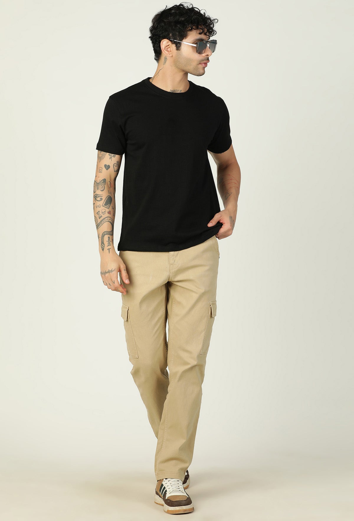 Men's solid black cotton T-shirt styled with beige trousers