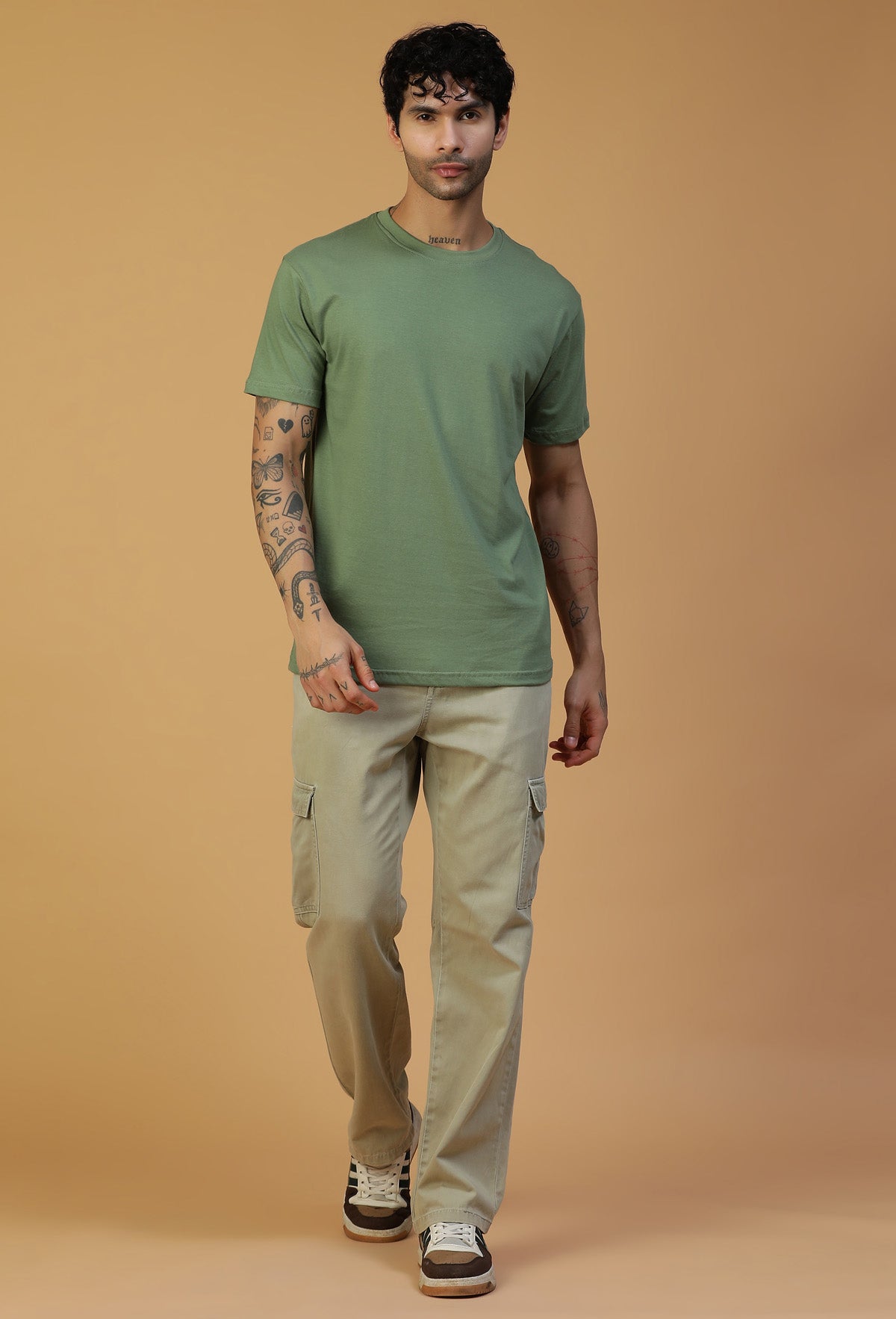 Man wearing an olive regular-fit cotton T-shirt with beige trousers