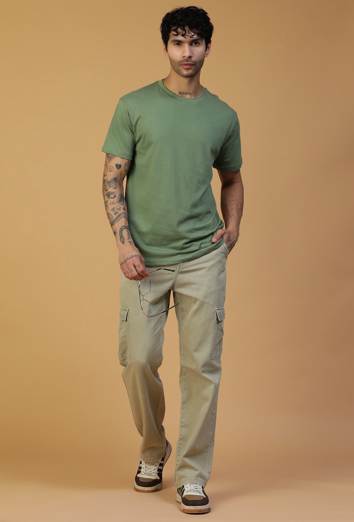 Full-length view of men's olive cotton T-shirt with beige trousers