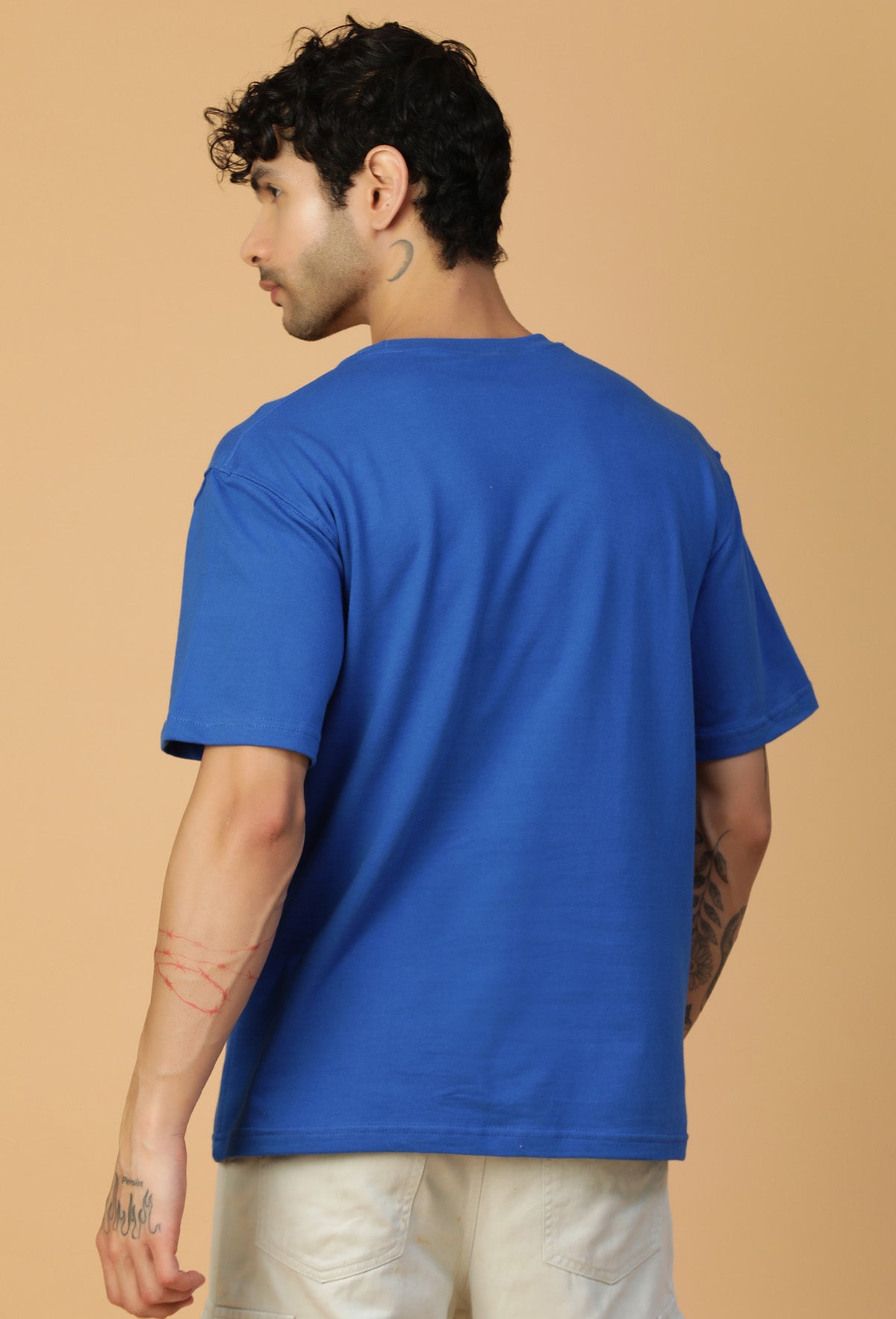 Man wearing a royal blue oversized cotton T-shirt with beige trousers