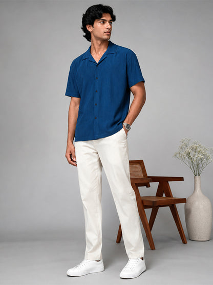 Men's royal blue textured shirt styled with white trousers