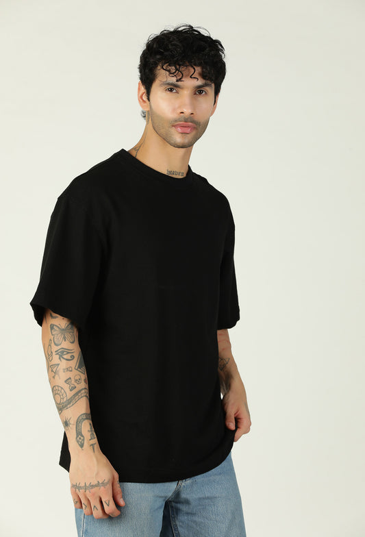 Man wearing a solid black pure cotton oversized T-shirt
