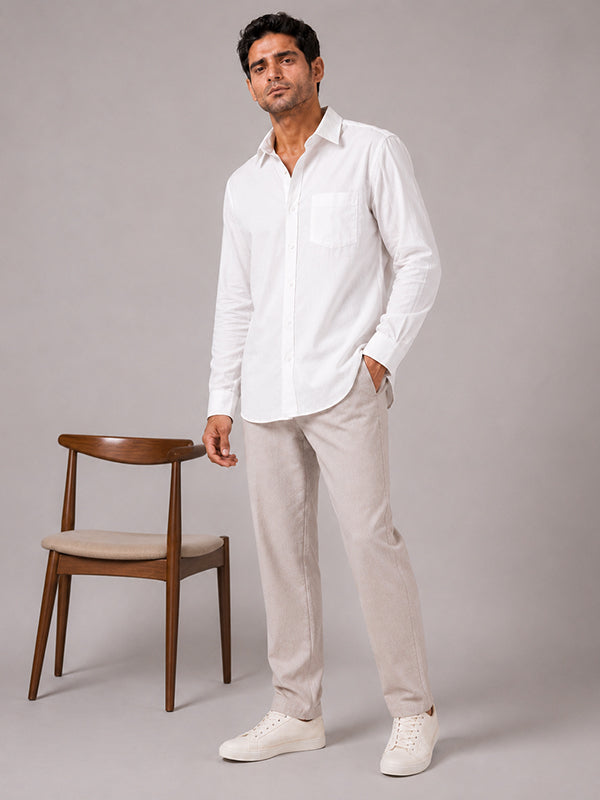 Men's white cotton full-sleeve shirt styled with beige trousers