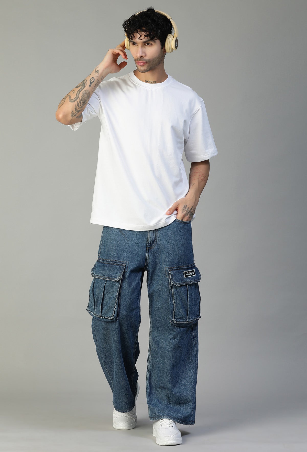 Man wearing a white oversized cotton T-shirt with blue jeans