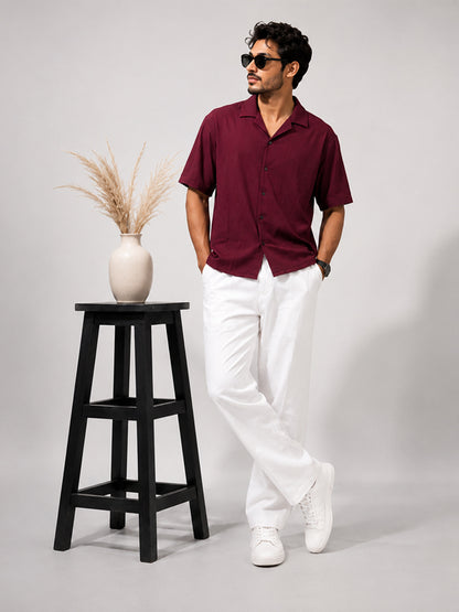 Alt text: Men's wine textured half-sleeve shirt styled with white trousers