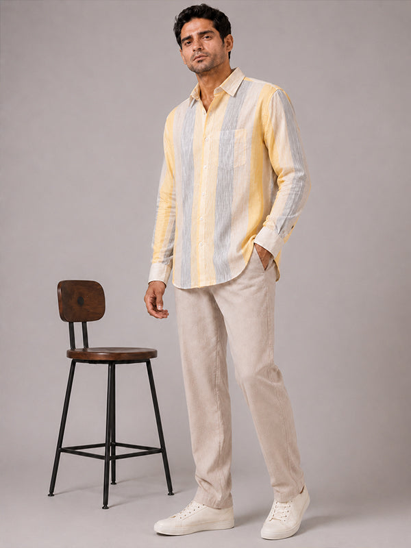 Men's yellow striped linen-cotton shirt styled with cream trousers