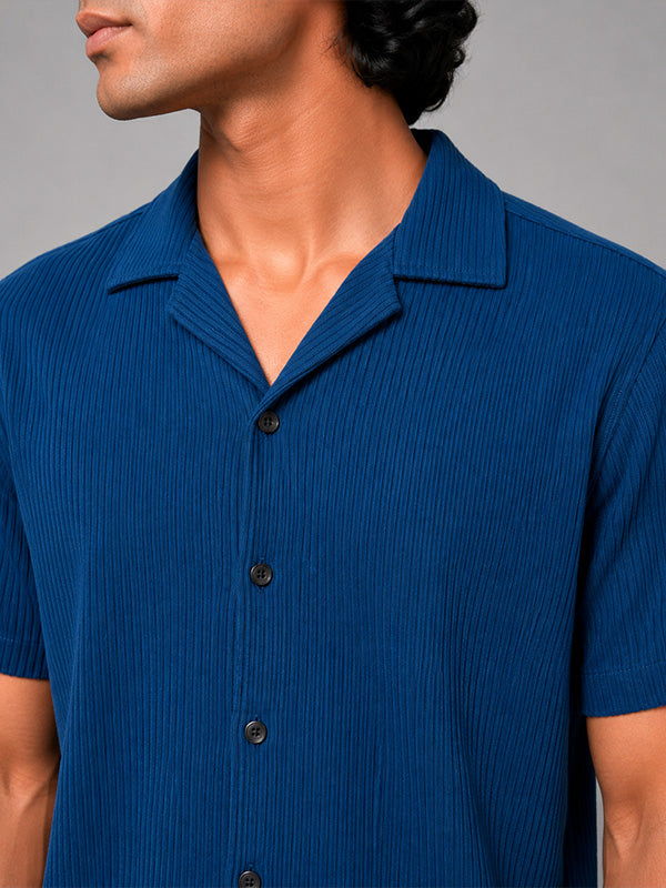 Close-up of royal blue ribbed shirt fabric, buttons and camp collar