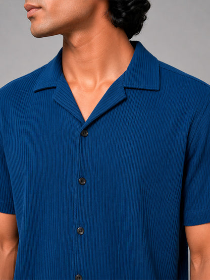 Close-up of royal blue ribbed shirt fabric, buttons and camp collar