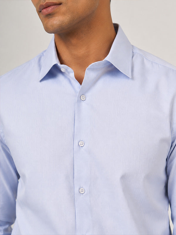 Close-up of sky blue textured cotton shirt collar, buttons and fabric